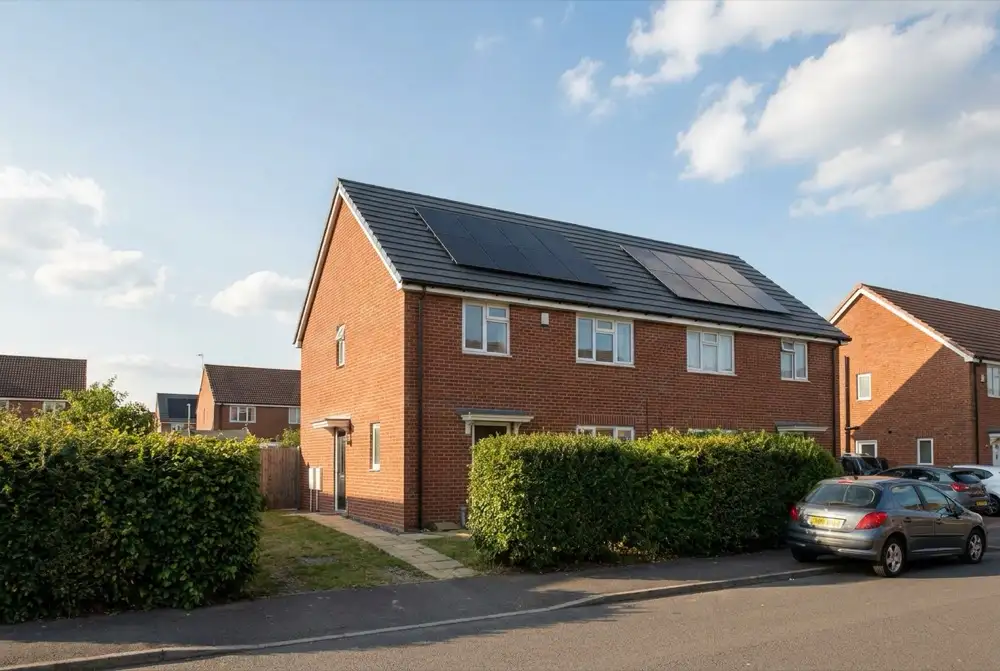 Doppelhaushälfte mit neuem dunklem Ziegeldach und schwarzen Solarmodulen